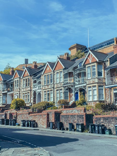 The image shows the front façade of two adjacent Victorian terraced houses with brick exteriors and white decorative trim around the doorways and windows. The property on the left features a light gr